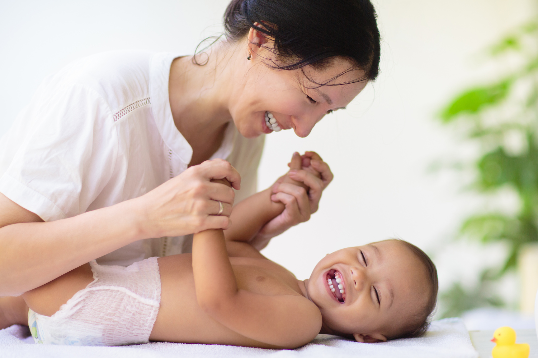 Mother changing diaper on newborn baby.